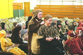 Katie Murk, from Missoula Children's Theatre, helps Makynna Lowry into her costume as part of Kaa the snake.