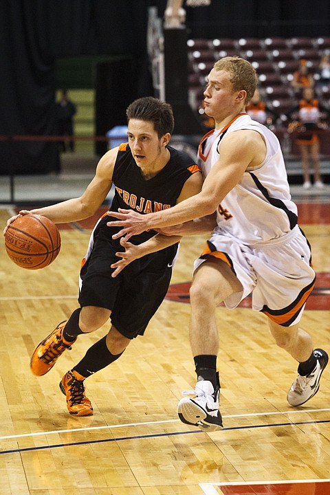 SHAWN GUST/Press

The Trojans' Kyle English drives past Idaho Falls' Alex Baker Thursday at the Idaho Center in Nampa.