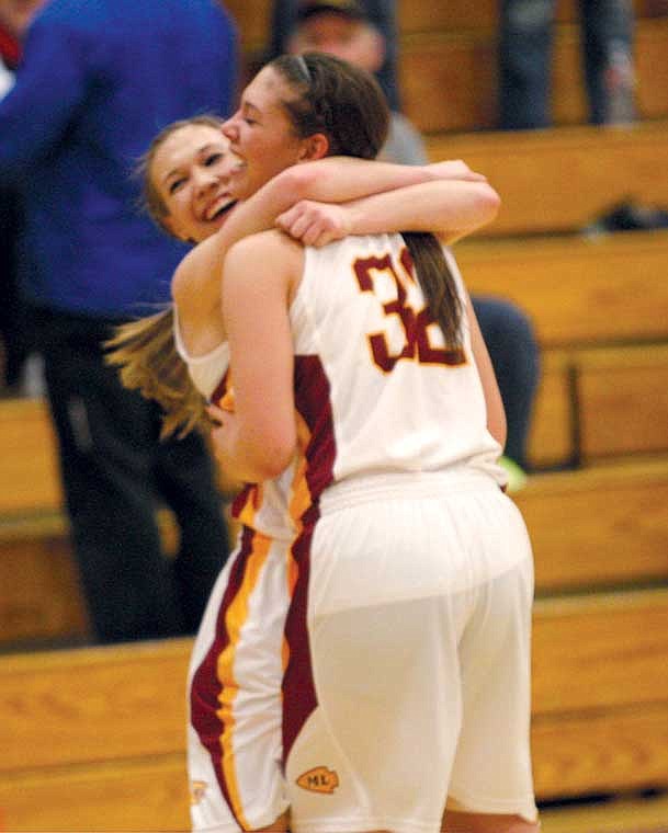 Moses Lake's Avery Clark and Stephanie Overland celebrate after the team's 61-40 win over Kentridge in Saturday's regional playoff game.