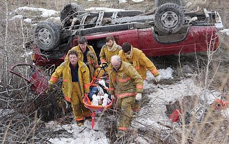 Members of the Hot Springs Fire Department carry Linda Blakemen, 61, up an embankment after a head-on collision on Highway 28 near Hot Springs. Blakemen was air-lifted to the Missoula Community Hospital, where she died.