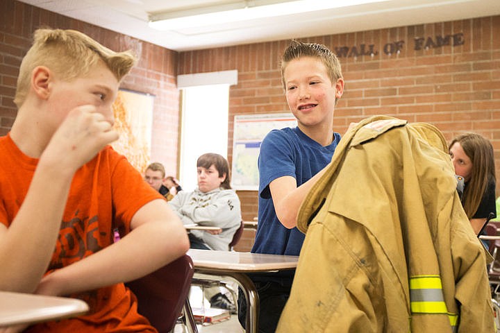 &lt;p&gt;Post Falls Middle School sixth-grader Damon Rosenau smiles at his classmate Nathanal Thomas when he realizes how heavy a fire fighter's jacket is, on Wednesday at the PFMS career day. Students listened to presentations given by representatives of many different careers such as hair dressers, law enforcement, fire fighters, attorneys, and more.&lt;/p&gt;