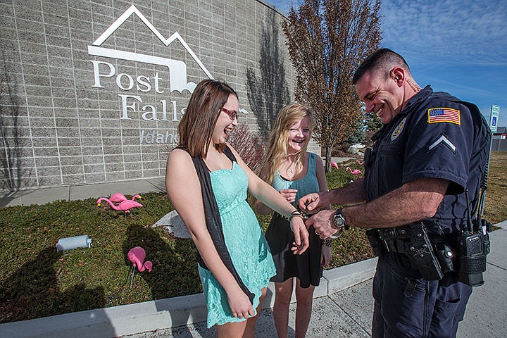 &lt;p&gt;Officer J.D. Putnam releases Megan Spradlin, left and Alexus Holbert from handcuffs after a posed photo following the Post Falls High School Dance Team&#146;s flocking the Post Falls Police Department. Megan and Alexus, members of the Post Falls High School Dance Team snuck onto Police Department on Thursday night and put pink flamingos on their front lawn &#147;holding them hostage&#148; until they made a donation. The Post Falls Police Association donated $100 to help send the Post Falls High Dance Team to the basketball state championships in Boise.&lt;/p&gt;