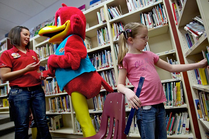 &lt;p&gt;JEROME A. POLLOS/Press Allison Thorsen, 8, browses the library books Tuesday at Atlas Elementary as Red Robin employee Jessi Hendricks talks the restaurant mascot. Hendricks and &quot;Red&quot; helped Atlas Elementary kick off &quot;Read Across America&quot; reading to second grade students.&lt;/p&gt;