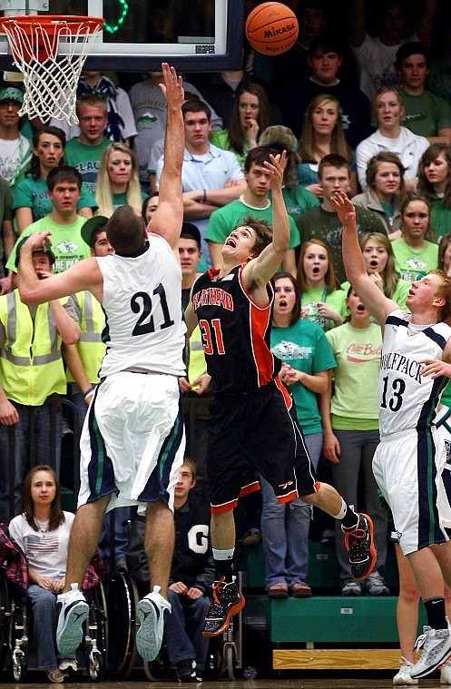 Flathead's Joe Pistorese tosses up a shot against the defending arm of Glacier's Shay Smithwick-Hann while Grahm Schmaltz looks on during a game on February 5 at Glacier High School. The two teams begin their playoff season's at home this evening, with Glacier hosting Helena at 6 p.m. and Flathead hosting Missoula Hellgate at 7:30 p.m.