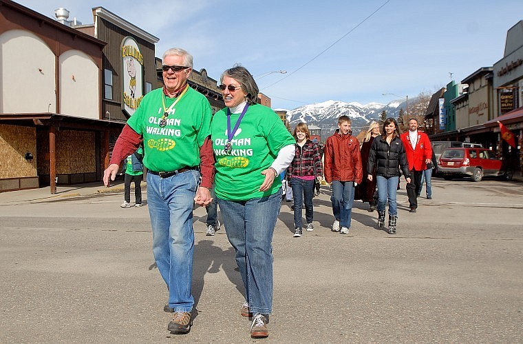 Richard Atkinson walks with his wife, Carol, and a crowd of supporters Friday through downtown Whitefish on his final day of his Old Man Walking campaign to raise money for the Whitefish Performing Arts Center.