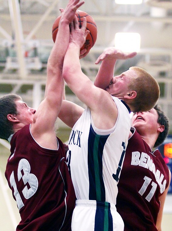 Glacier's Grahm Schmaltz is sandwiched between the defense of Helena's (Adam Johnson) and Zach Hulse (11) during the second quarter of Thursday evening's playoff game at Glacier High School.