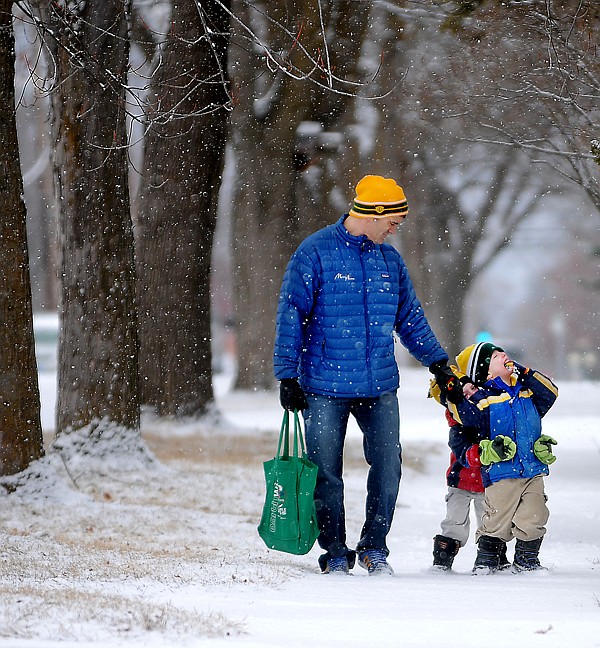 <p>Enjoying the Snow Jason Rasco of Kalispell treks home from a visit to the library with his 4 year old twin boys Macy, in red, and Mac, in blue, on Wednesday morning in Kalipsell. The twins were enjoying the catching and eating the freshly falling snow.</p>