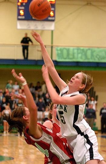 Glacier Wolfpack guard Rachel Cutler draws a foul on a drive to the basket against Helena High's Kelsey Williams. Allison Money/Daily Inter Lake