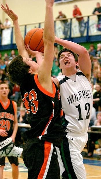 Glacier Wolfpack guard Connor Fuller angles around Flathead Braves post Connor Tice for a basket during the first half of the Thursday's Western AA play-in game at Glacier High School. Allison Money/Daily Inter Lake