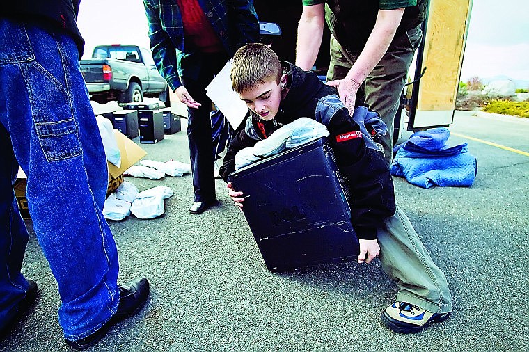 &lt;p&gt;SHAWN GUST/Press Cody DeVaugh, a seventh-grader at River Middle School, bends down to pick up a computer, his first, during a distribution Thursday of refurbished machines from the nonprofit group, Computers for Kids. Nearly 20 computers were delivered to Post Falls students who wrote essays about how they would use the computers.&lt;/p&gt;