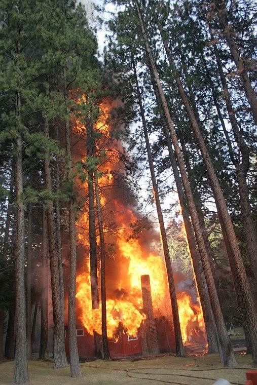 &lt;p&gt;In a burst of air from a collapsing internal floor, flames from the house fire at 1882 Montana highway 135 rise up into the air some 30 feet, catching the surrounding pine on fire.&#160;&lt;/p&gt;