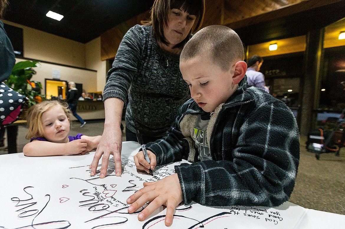 &lt;p&gt;Alexa Leingang, 3, watches as Denise Markley, the children&#146;s ministry administrator for Candlelight Christian Fellowship, helps older brother Jayden, 6, to signs a poster board for pastor Remington.&lt;/p&gt;