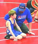 Coach Jason McLees offers Kaden Hill some advice during his match last Thursday night.