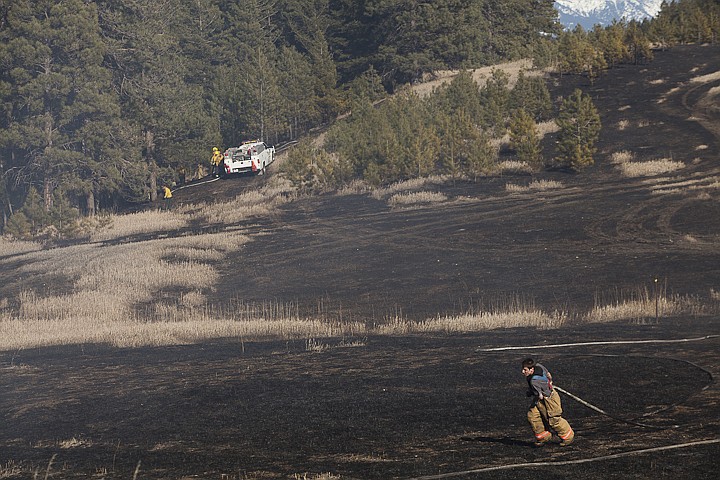 &lt;p&gt;Patrick Cote/Daily Inter Lake Smith Valley firefighter Travis Cik drags a hose across the scorched ground of a 50-acre fire off of Whalebone Drive west of Kalispell Friday afternoon. Friday, March, 9, 2012 in Kalispell, Mont.&lt;/p&gt;