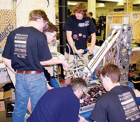 &#151;COURTESY PHOTO&lt;br&gt;The Alpha+ Robotics team focuses on a final checkup on Bosco just before the competition in Oregon. Pictured from l-r bottom row: Mike Tymrak and Jeff Howard. Top row from l-r: Tristan Mullis, Brennan Tymrak, and in the middle Jacob Wati.