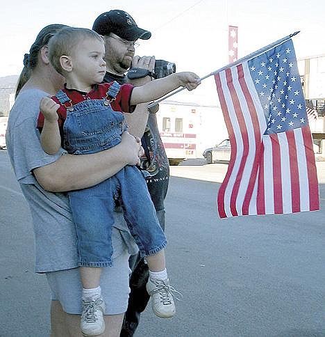 Tessa Roberts holds 2-year-old Cruzier Sharp while Jeff Sharp operates a video camera Friday afternoon as members of the National Guard's 639th Unit arrive in Libby after a year in Iraq.