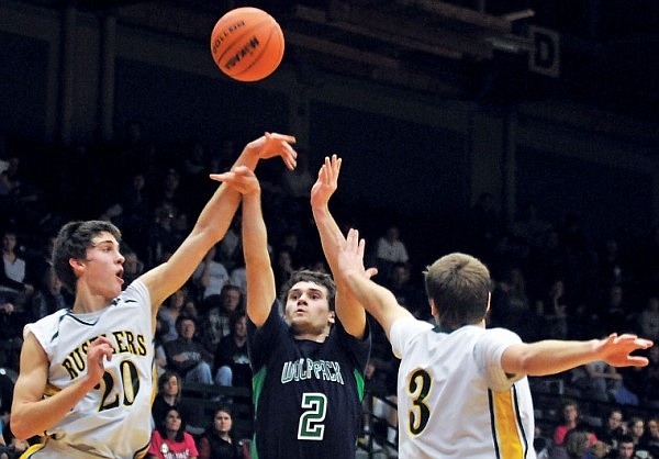 Glacier's Bryan Chery (2) puts up a shot between the defense of arms Great Falls CM Russell's Tylcer Stanich (20) and Kurtis Parson (3).