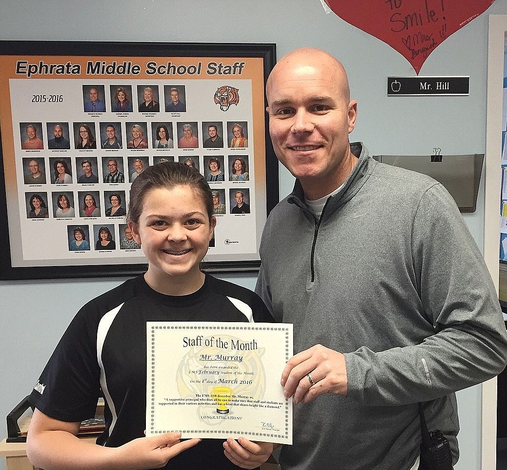 ASB eighth-grade girls representative Chloe Davis presents Mr. Murray with a certificate recognizing him as Staff Member of the Month.