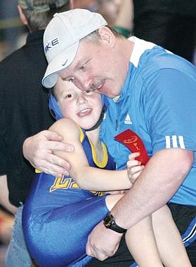 Paul Sievers/The Western News Pee-wee wrestler Blake Knapp gets a hug from Dean Thompson during Saturday&'s Kootenai Klassic in Libby.