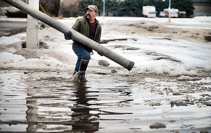 &lt;p&gt;Mark Gettig of Badger Excavating works to suction up a pool of melted snow at Lane's Conoco on Thursday, along Montana 35 in Evergreen. Getting estimated they had filled one truck with 8,000 gallons and would likely need to make three more trips to deal with the flooding problem. (Brenda Ahearn/Daily Inter Lake)&lt;/p&gt;