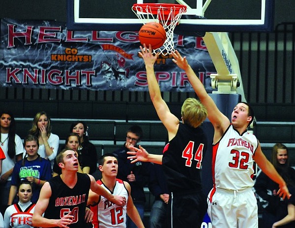 Flathead's George Sherwood jumps up to defend against Bozeman's Brandon Rydberg (44) as Flathead's Mike VanArendonk (12) and Bozeman's Lincoln Powers (50) keep their eye on the ball.