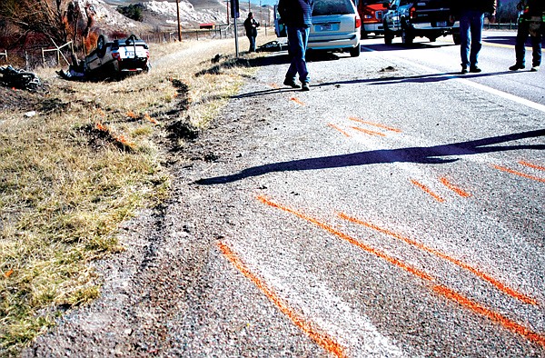 Law enforcement officials survey the scene at a Sunday, March 7, wreck that killed one woman.