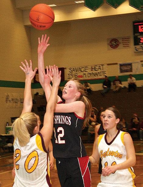 Photos by Aaric Bryan Savage Heat&#146;s MacKenzie Wood goes up for a shot over Harlowton&#146;s Kelsey Robertson at the Belgrade Event Center Thursday. Wood finished with 17 points in the 62-57 overtime loss.