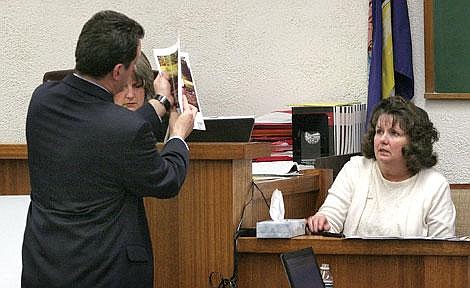 Photos by Adam Herrenbruck Daniel Guzynski, a Montana assistant district attorney, shows lead witness Candice Guill old photographs of the Guill family of when they lived together in Heron. He then showed them to the jury members. Guill took the stand last Tuesday as a witness against her former husband.