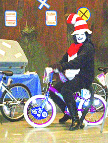 Gloria Curdy dressed up to play the Cat in the Hat. Here, the Cat shows off the two bikes that were donated by the Mineral County Masons.