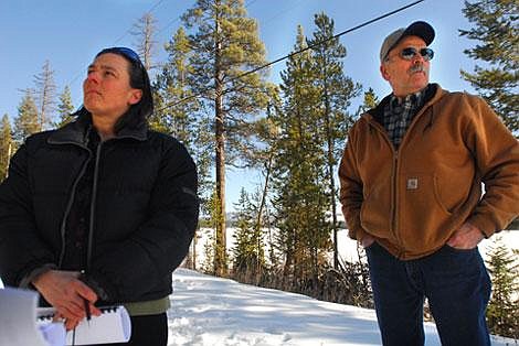 Flathead Wildlife Inc. attorney Diane Conradi, left, and Flathead Wildlife Inc. member Warren Illi discuss the steep grade of the new private road, right, compared to the flat county road to the left on the north shore of McGregor Lake. The county road was blocked off at the west end and buildings were built on and next to the road. Garret Cheen/Daily Inter Lake