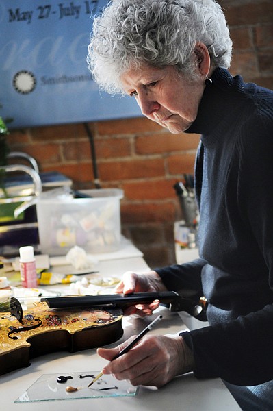 <p>Karen Leigh, one of several artists creating work for the upcoming Virtuoso Violins, a fundraiser for Glacier Symphony and Chorale, puts the finishing touches on her violin Thursday afternoon at her studio in Kalispell. According to Lakeside resident Margene Berry, one of the auction organizers, the artists have donated 100 percent of the proceeds to the symphony. The other artists participating in the Virtuoso Violins auction are Nancy Cawdrey, Nick Oberling, Jennifer Li, Rochelle Lombardi, Mark Ogle, Rob Akey, Jeff Manion, Jeffrey Funk, Marla Edmiston, Susan Guthrie, Tara Moore and David Secrest.</p>