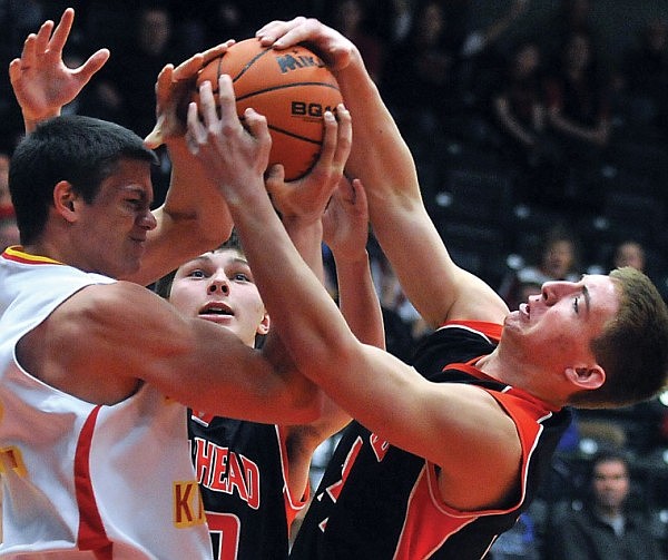 Flathead's Matt Tokarz, right, and Missoula Hellgate's Connor Woodill both keep a tight grip in an attempt to get possession of the ball as Flathead's Shea Schroeder looks on.