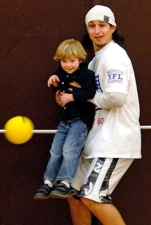 Pittsburgh Steelers Defensive Back Tuff Harris holds up Charlie Hyatt, 4, as a shield against incoming balls during a game of dodge-ball.