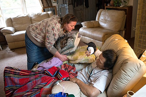 &lt;p&gt;Gail Perry, left, adjusts pillows for Bearpaw Galindo to keep his right hand elevated.&lt;/p&gt;