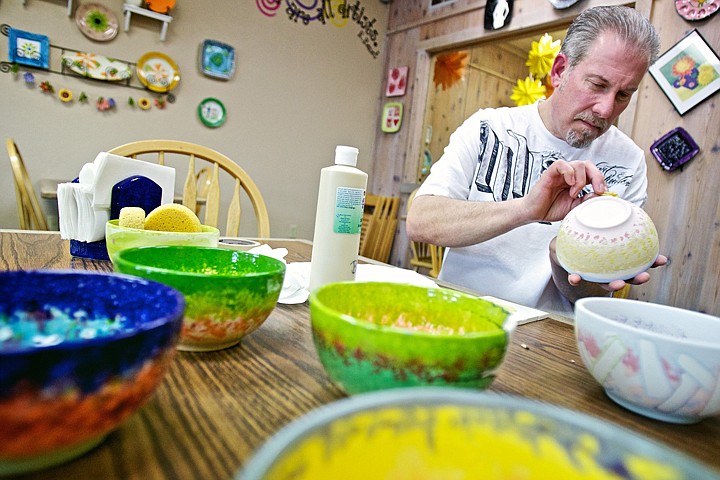 &lt;p&gt;JEROME A. POLLOS/Press Chris Heath applies paint Tuesday to one of the 20 bowls he's designing at Hands to Art for this weekend's Empty Bowl fundraising project benefitting the Coeur d'Alene and Post Falls food banks. Participants of Saturday's event pay $12 per handcrafted bowl that will be filled with homemade soup.&lt;/p&gt;