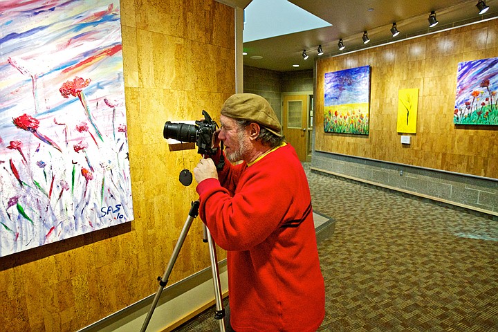 &lt;p&gt;JEROME A. POLLOS/Press Steven Scroggins takes photos of his paintings after hanging them Friday for his &quot;Spring in Bloom&quot; show at the Coeur d'Alene Public Library.&lt;/p&gt;