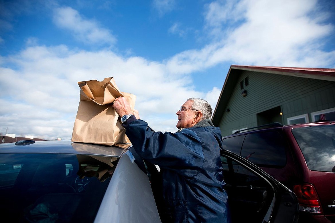 &lt;p&gt;Dick Harris of Post Falls, who has volunteered with Meals on Wheels for 20 years, loads paper bags of food bound for delivery to home-bound people into his car on Wednesday in the Post Falls Senior Center parking lot.&lt;/p&gt;