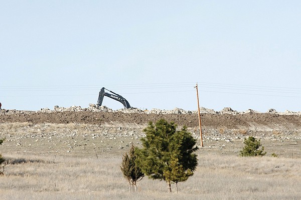 A crane at the base of Chief Cliff moves stones March 15 at a quarry site. Western Stone operates the quarry site and sells Chief Cliff stones to landscapers, stone masons, architects and contractors.