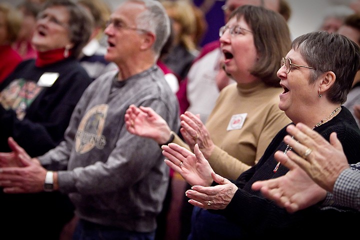 &lt;p&gt;Val Simkins, right, and Jane Orto, clap their hands as they work through a song with the Northwest Sacred Music Chorale.&lt;/p&gt;