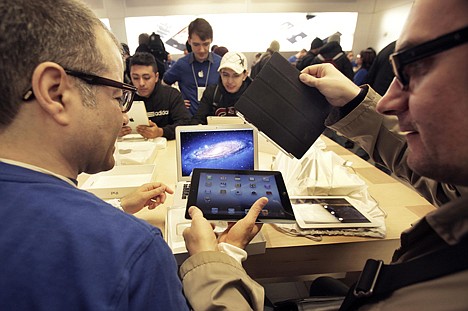 &lt;p&gt;An Apple employee, left, assists a man with his new iPad at Apple's flagshop store, in New York on Friday. Apple's latest iPad drew die-hard fans to stores in the U.S. and nine other countries Friday, many of whom lined up for hours to be among the first to buy one.&lt;/p&gt;