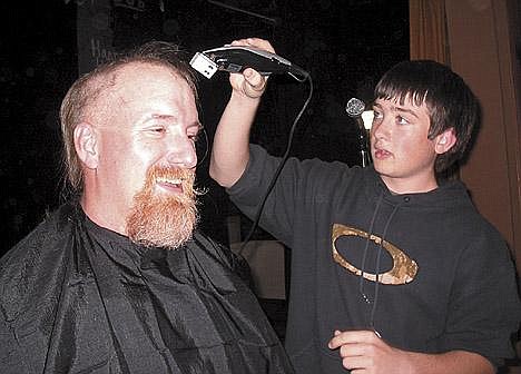 Eighth-grader Clayton Kyriss was one of several students who took turns shearing Troy High School counselor Kelly Palmer on Wednesday.