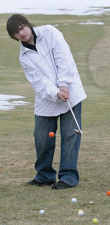 Photo by Nick Ianniello St. Regis golfer Zane Worrall works on his chip shot in an open field at the Trestle Creek Golf Course. The team has battled snowy conditions and cold weather during their first week of practices.