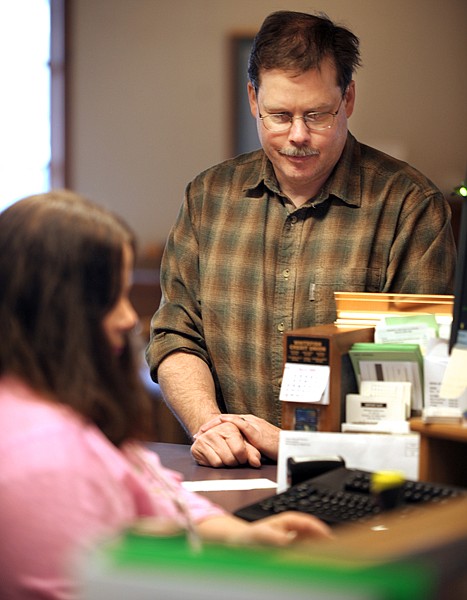 Brenda Ahearn/Daily Inter Lake
Eric Schenck of Whitefish works with teller Betty DeRosa of the Whitefish Credit Union on Thursday.