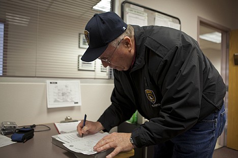 &lt;p&gt;Rob Clifford, coordinator for the Coeur d'Alene Police Department COPS Volunteer Program, works on completeting paperwork for an abandoned vehicle that was towed during his shift Thursday.&lt;/p&gt;