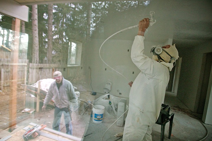 &lt;p&gt;Greg Nowak, construction director for Habitat for Humanity of North Idaho, spray paint on the ceiling as Jim Pontier, a volunteer, works outside on installing siding Tuesday at the first home built at the Hamilton Woods Habitat for Humanity site in Coeur d'Alene.&lt;/p&gt;