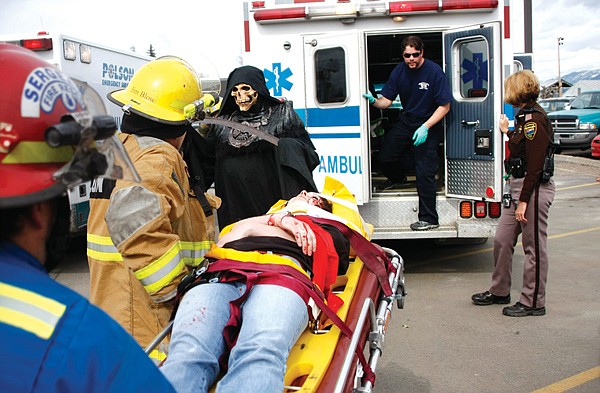 Members of the Ronan Fire Department rush a victim past the Grim Reaper during a simulated drunk driving crash March 18 as part of Ghost-Out Day. The event happens every four years and educates students on the dangers of drunk drivers.