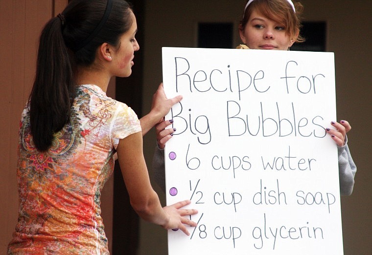 Beca Gunderson, left, shows how to make big bubbles and a homemade bubble maker with the help of Velita Benson.  The demonstration was called &quot;Bubble Trouble.&quot;