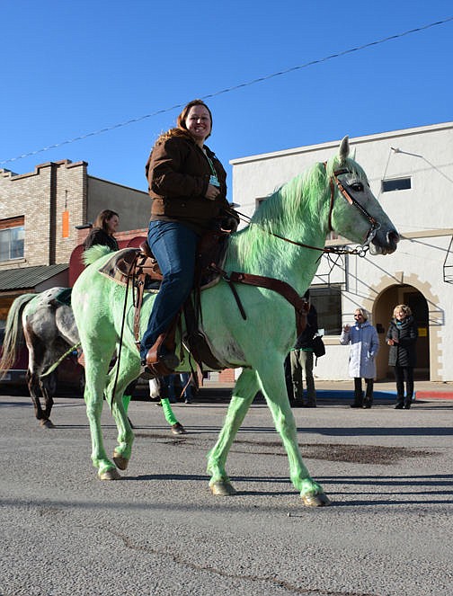 &lt;p&gt;A parade participant rides atop green horse in downtown March 17.&lt;/p&gt;