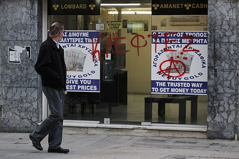 &lt;p&gt;A man passes a sprayed entrance of a store that buys gold which reads in Greek &quot;thieves&quot; in Nicosia, Cyprus, Monday. Cyprus secured what its politicians described as a &quot;painful&quot; solution to avert imminent bankruptcy, agreeing early Monday to slash its oversize banking sector and make large account holders take losses to help pay to secure a last-minute $13 billion bailout.&lt;/p&gt;