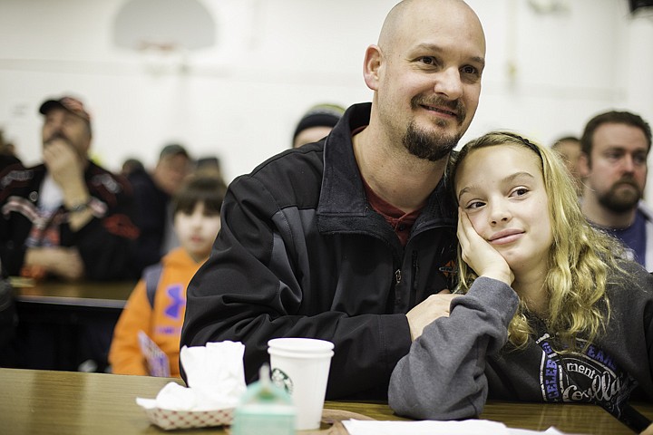 &lt;p&gt;SHAWN GUST/Press Bruce Foster and his daughter Lily, 11, watch a musical performance Friday during Dads and Donuts at Bryan Elementary School. 275 attended the event at the Coeur d'Alene school.&lt;/p&gt;